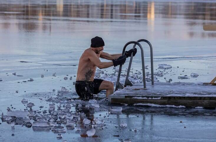 Shirtless man in freezing lake near Ludvika, Sweden, captured during a winter swim. Sublime ice scenery.