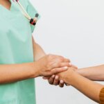 Close-up of a doctor holding a patient's hands, symbolizing trust and empathy in healthcare.
