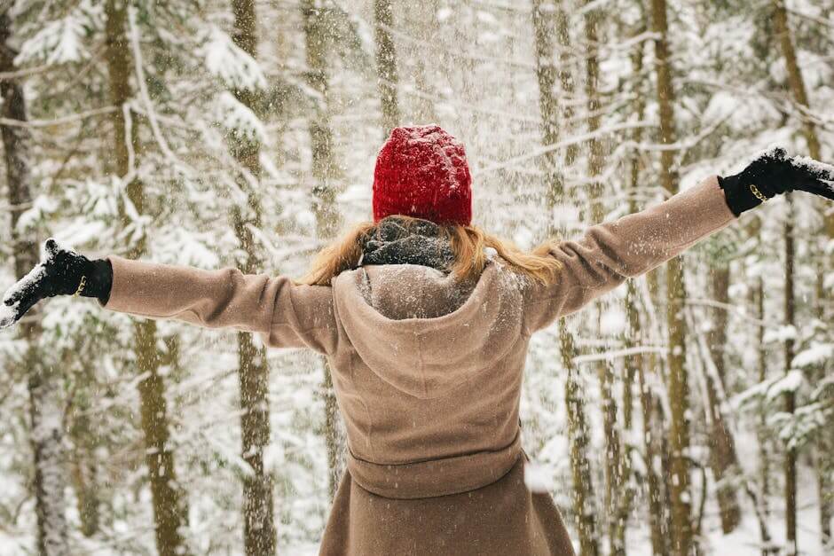 Woman in red hat enjoying a snowy winter day in Lake Placid forest.