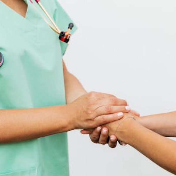 Close-up of a doctor holding a patient's hands, symbolizing trust and empathy in healthcare.